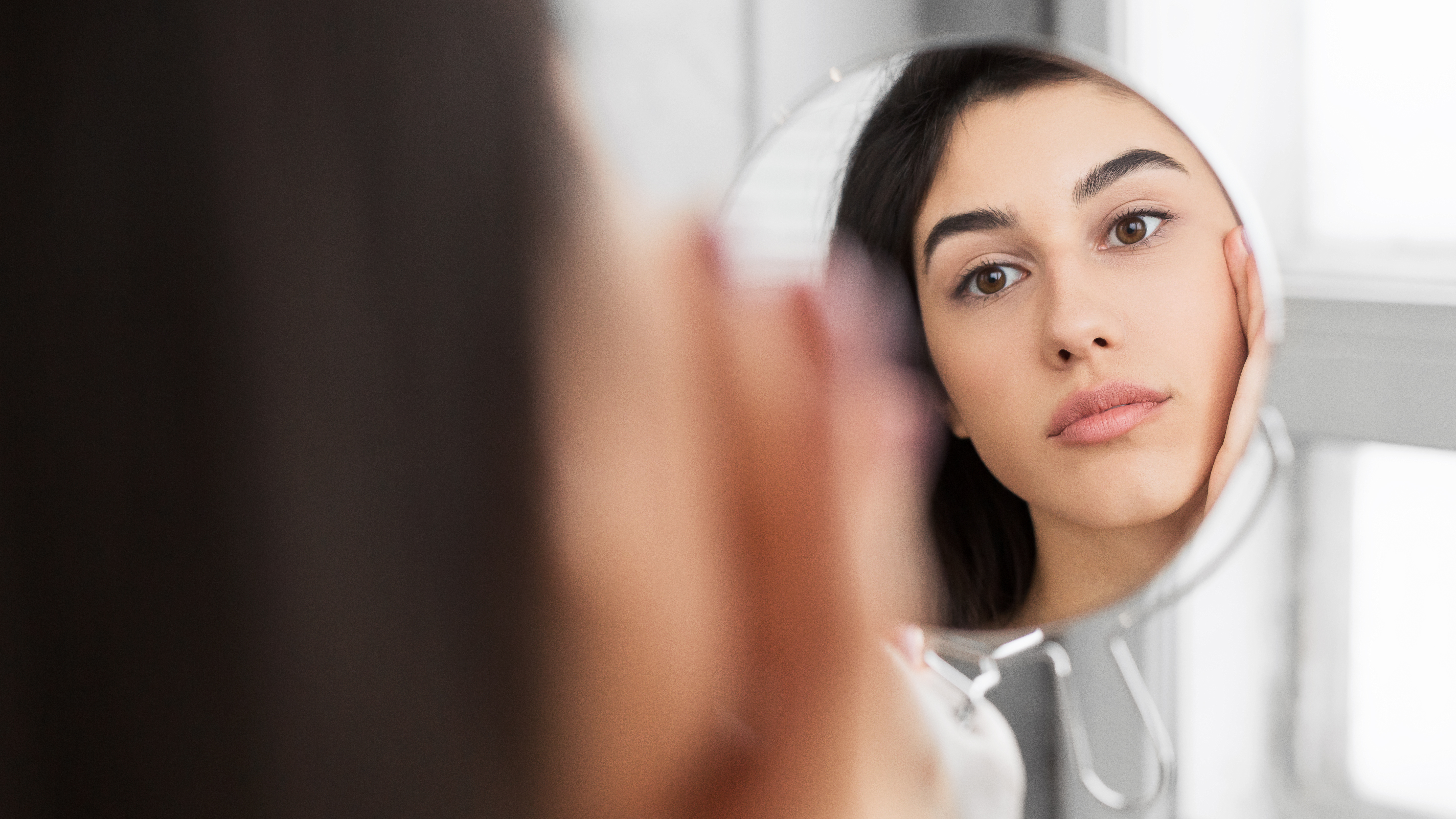 Girl Touching Face Looking In Mirror