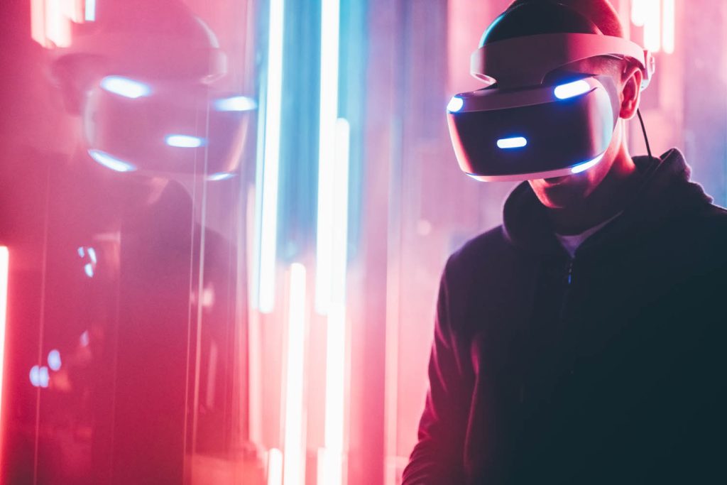 Person wearing a VR headset next to neon lights