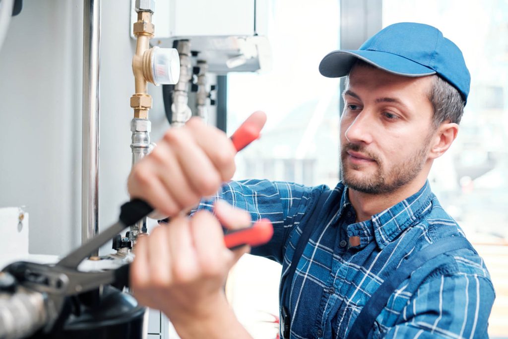 Plumber fixing pipes with wrench
