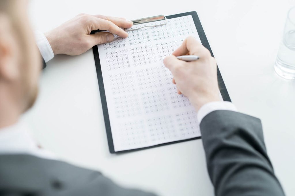 Person completing a multiple choice answer sheet