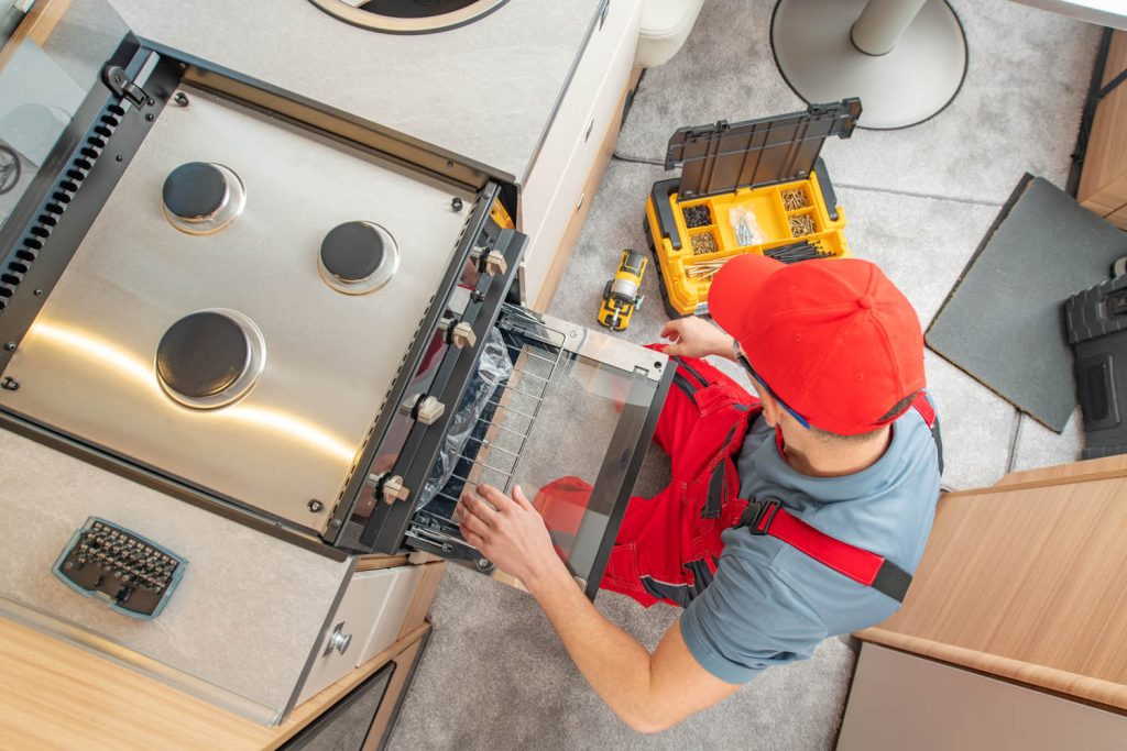 Workman fixing gas oven