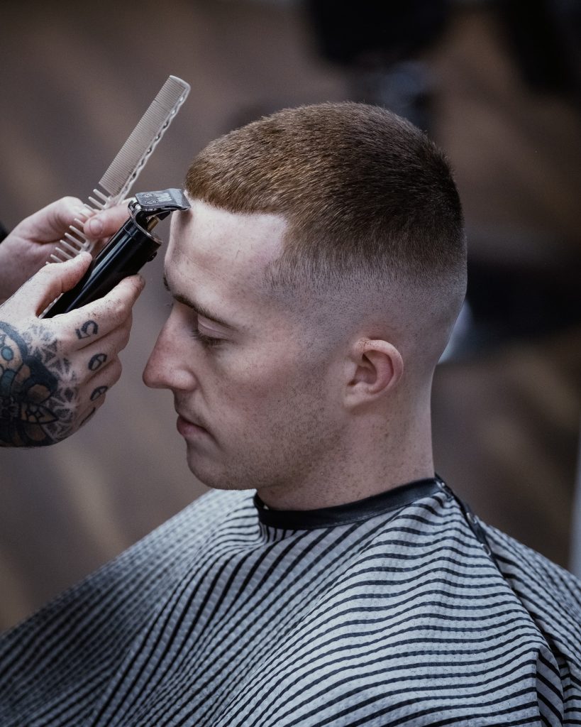 Person having hair trimmed with clippers