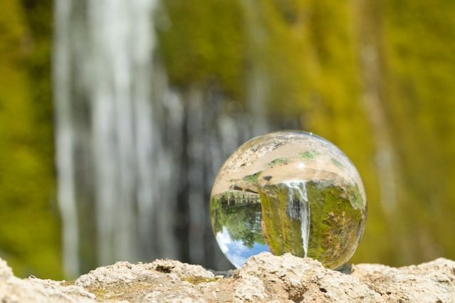 Glass globe in front of waterfall