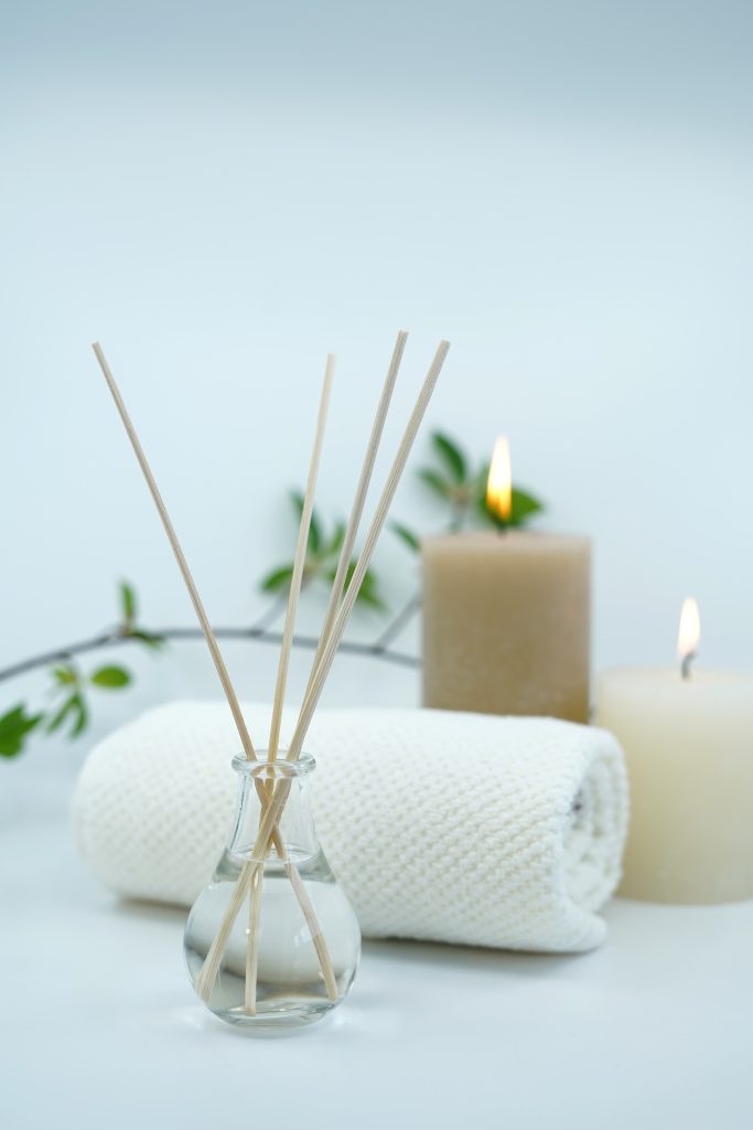 Reed difuser and candles on white background