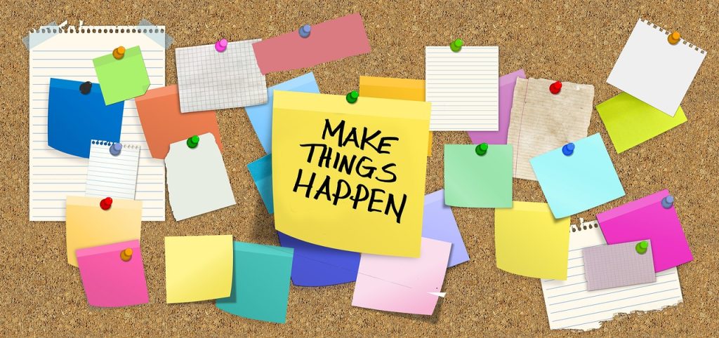 post-it notes and blank pieces of paper pinned to a notice board