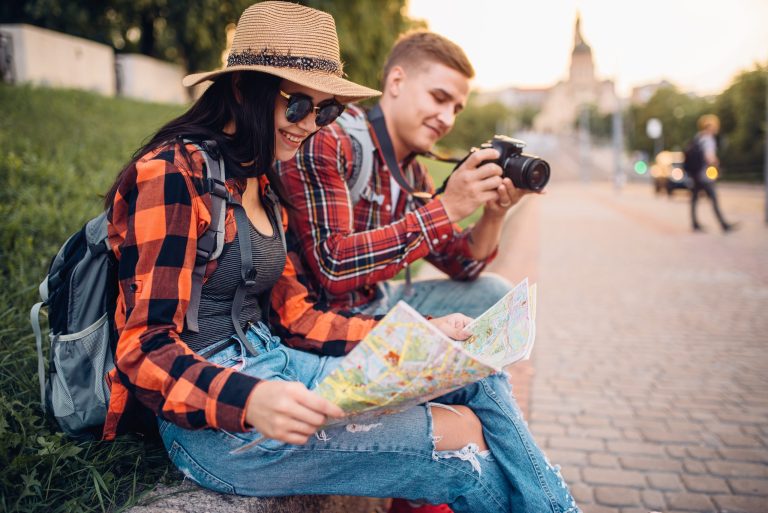 Person reading a map and a person looking at a camera.