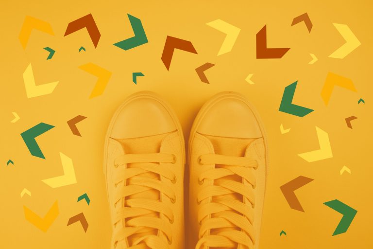 Yellow trainers on yellow background with multicoloured arrows.