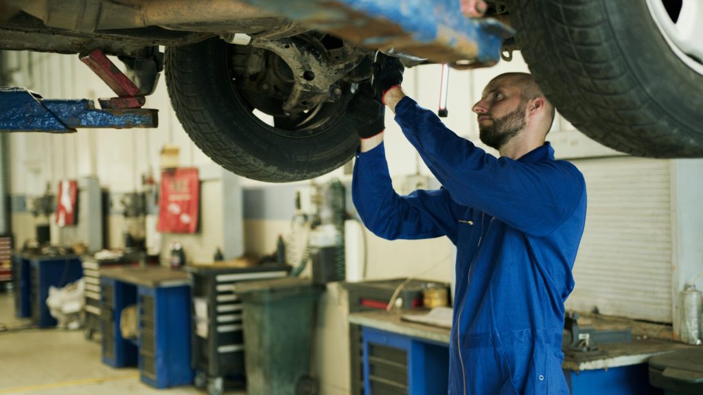 man working on the underside of a car