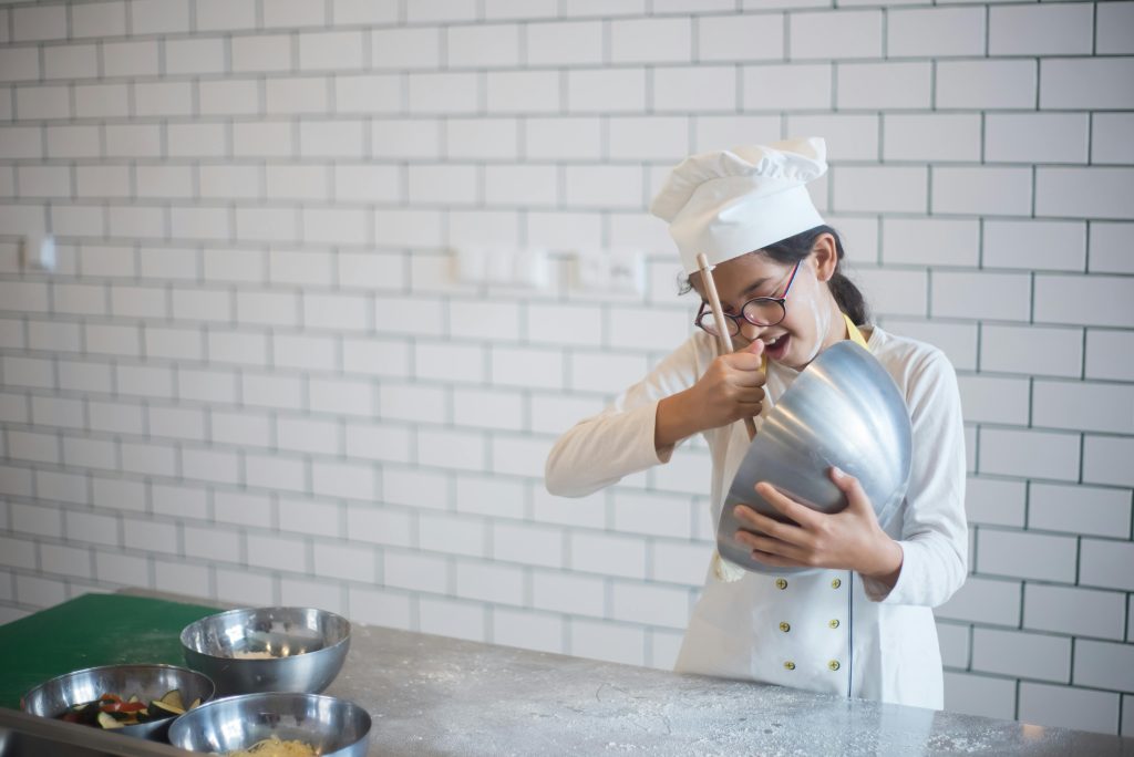 girl in chefs hat baking