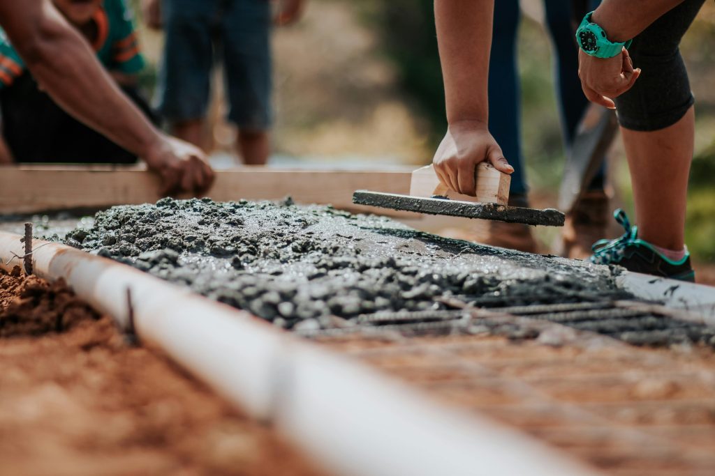 people flattening wet concrete