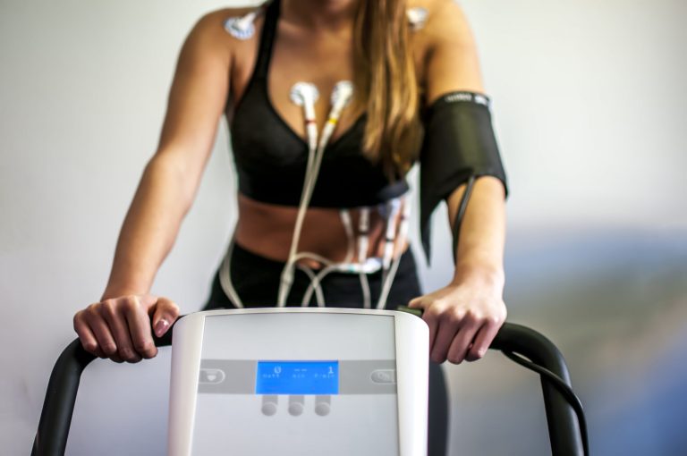 Torso of person on treadmill with monitoring equipment attached.