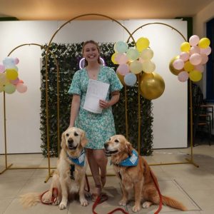 Student holding paper, with two dogs
