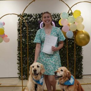 Student holding paper, with two dogs