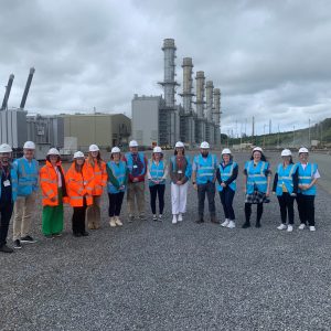 Group of staff and students in high viability jackets outside refinery